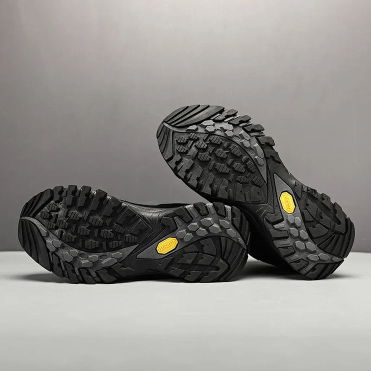 Rugged black outsoles of TrailMaster Pro Trek Boots showing deep traction grips for hiking and outdoor adventures.