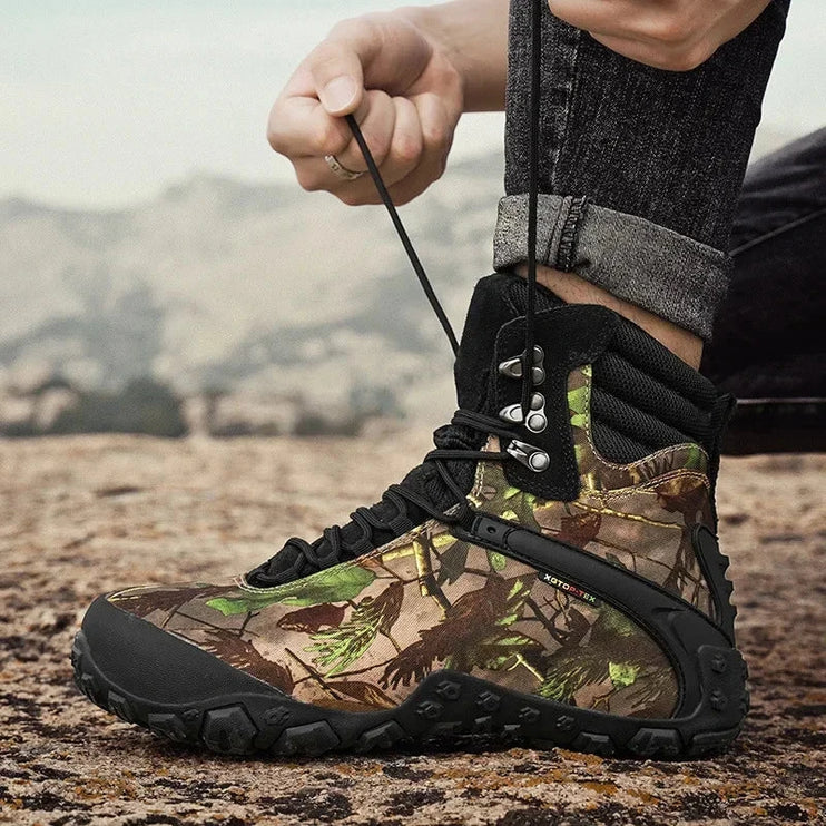 Person lacing up TerraGuard Tactical Boots with camouflage pattern on a rocky terrain, perfect for outdoor adventures.